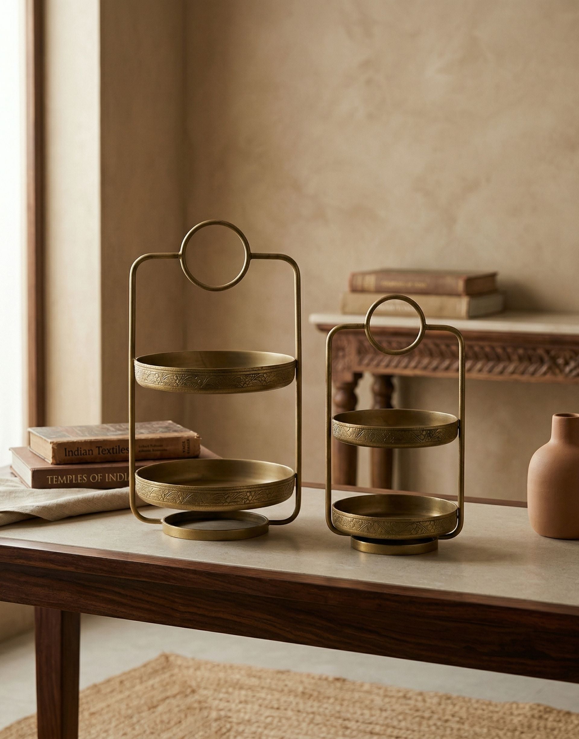 Brass tiered stand and holder on a wooden table with a neutral background