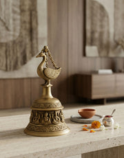 Decorative brass bell with intricate designs on a wooden surface.