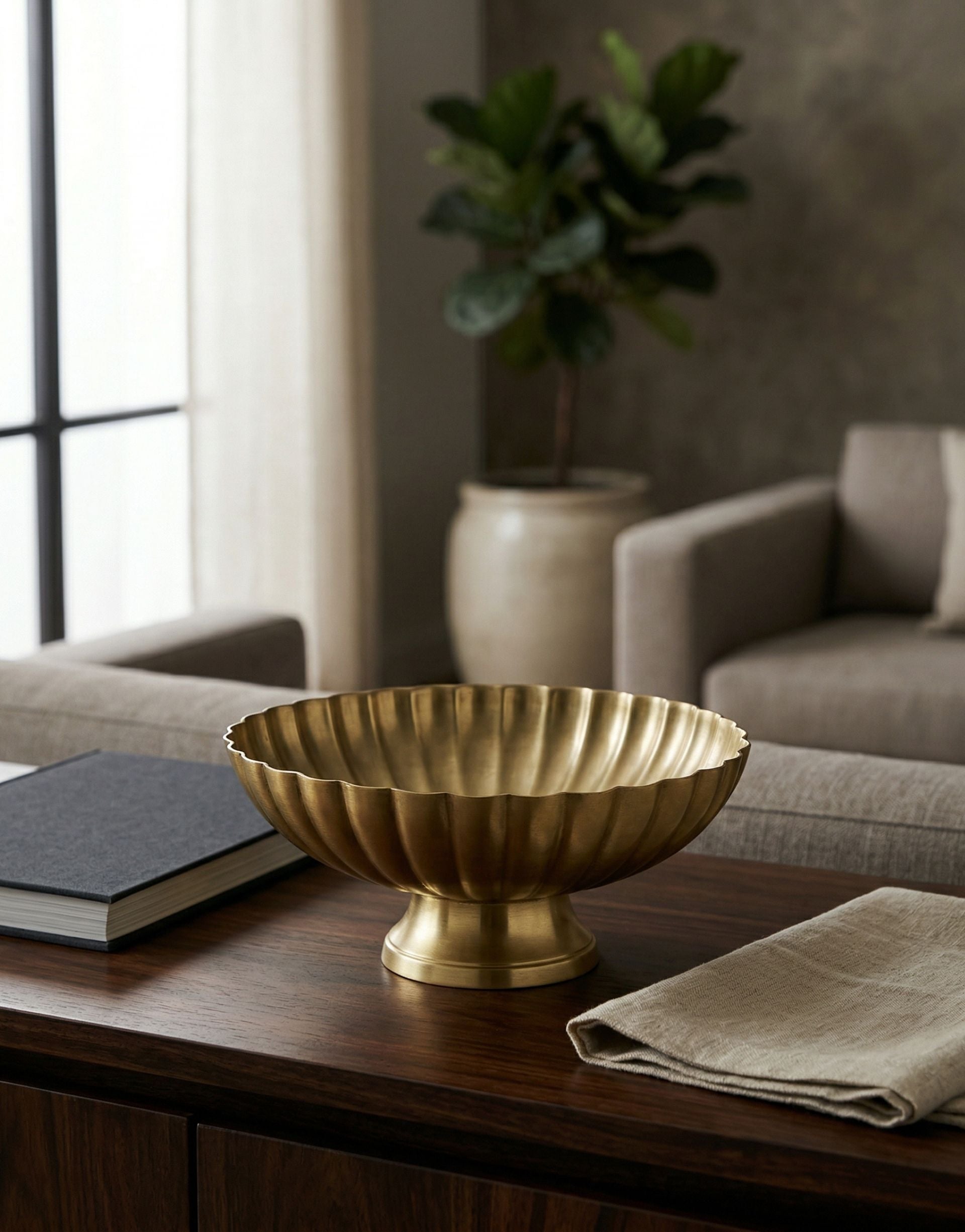 Brass decorative bowl on a wooden table with a blurred background of a living room.