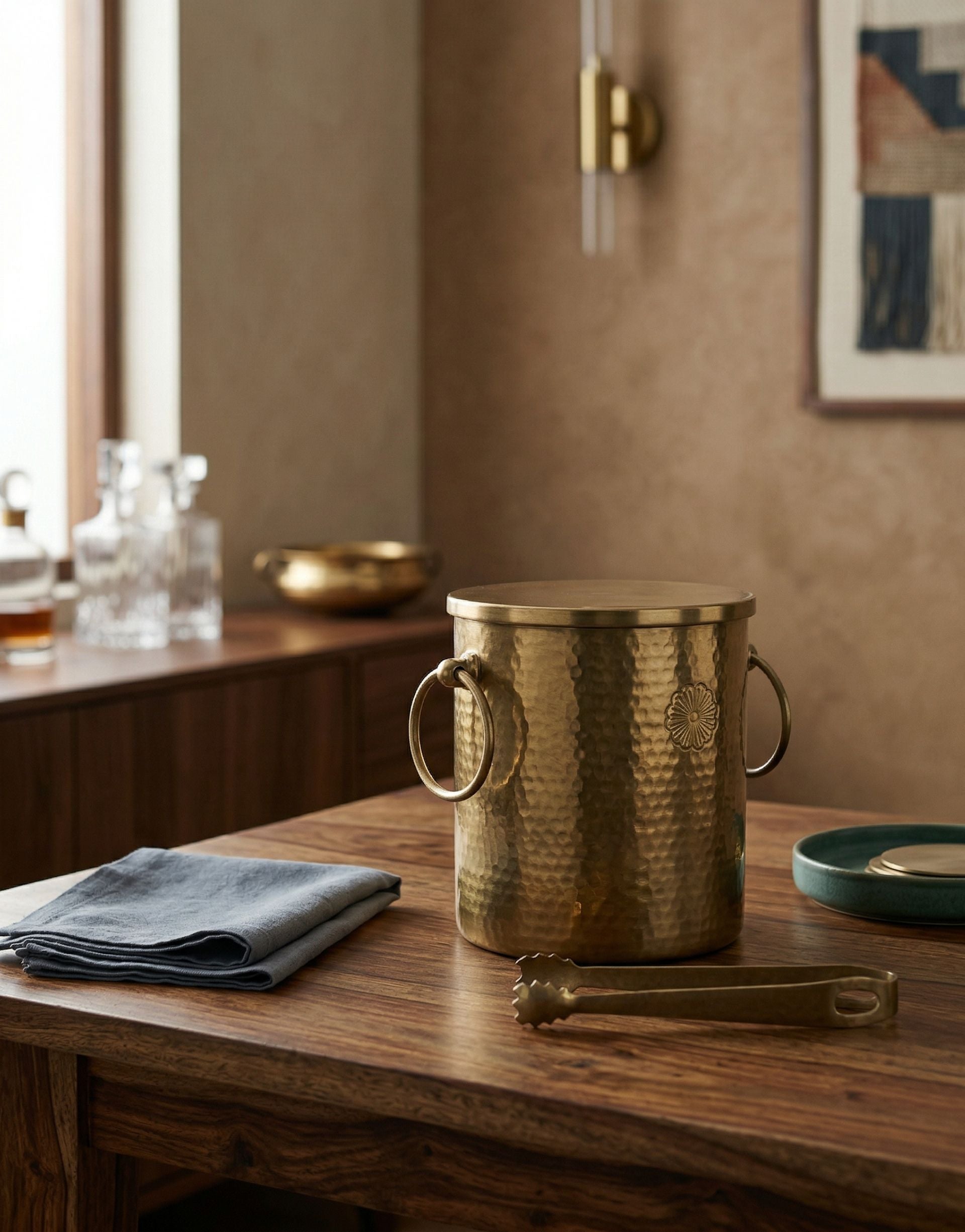 Brass ice bucket on a wooden table with a neutral background