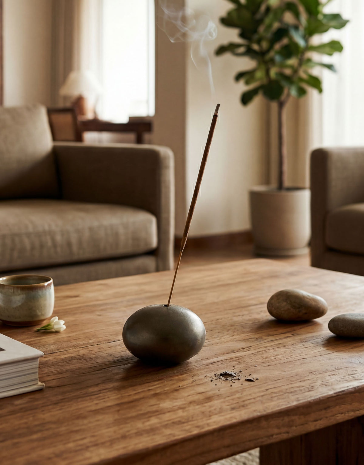 Brass Incense stick in a holder on a wooden table with a blurred living room background