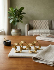 Decorative brass table napkin rings on a marble tray in a living room setting